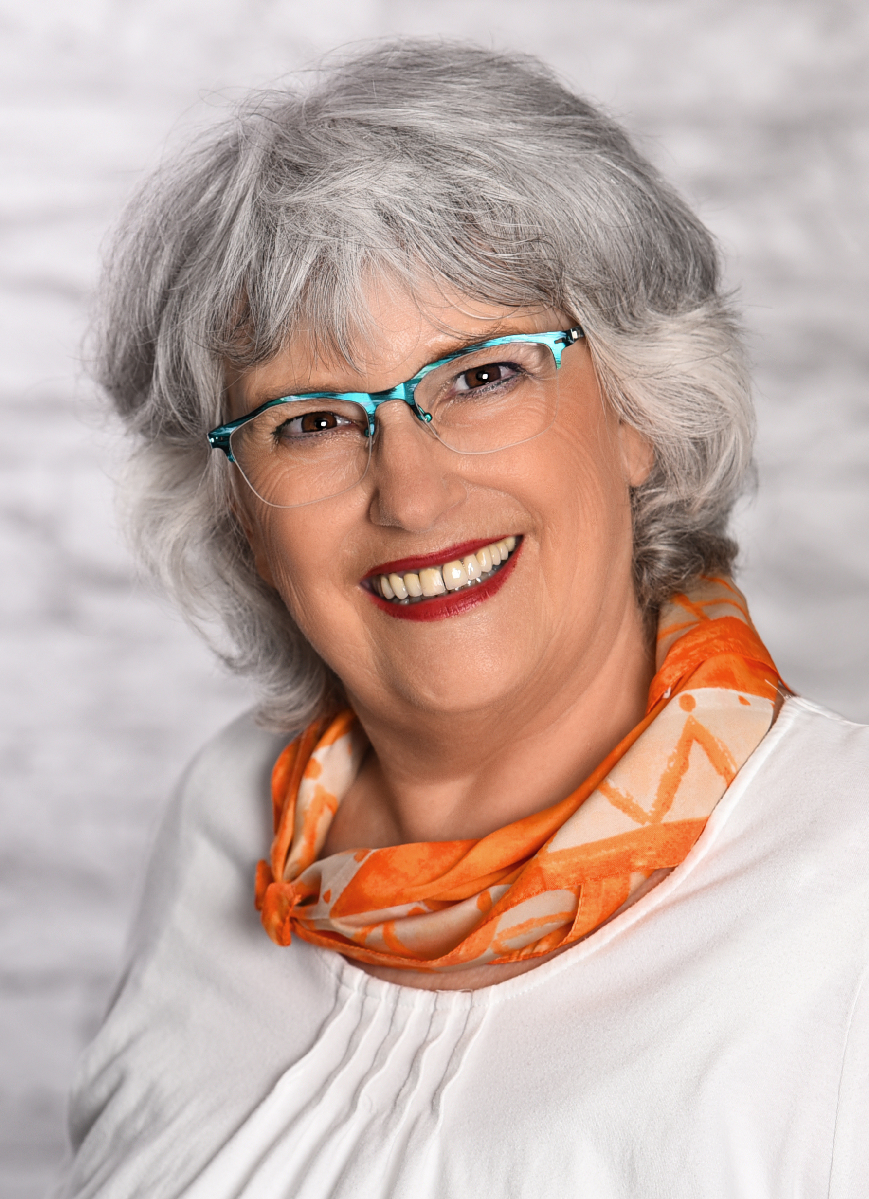 Profilfoto Ursula Widmann-Rapp ( weiße Bluse und orangefarbener Schal )